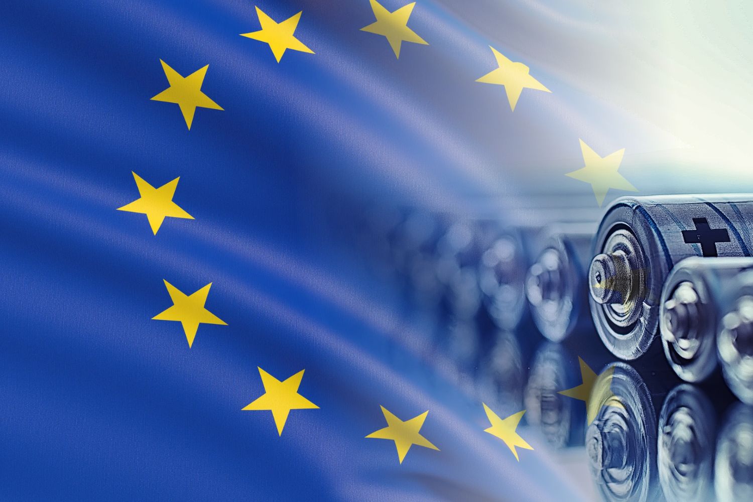 Baterii cu simbolul plus plasate pe o suprafață reflectorizantă, cu steagul Uniunii Europene estompat în fundal.